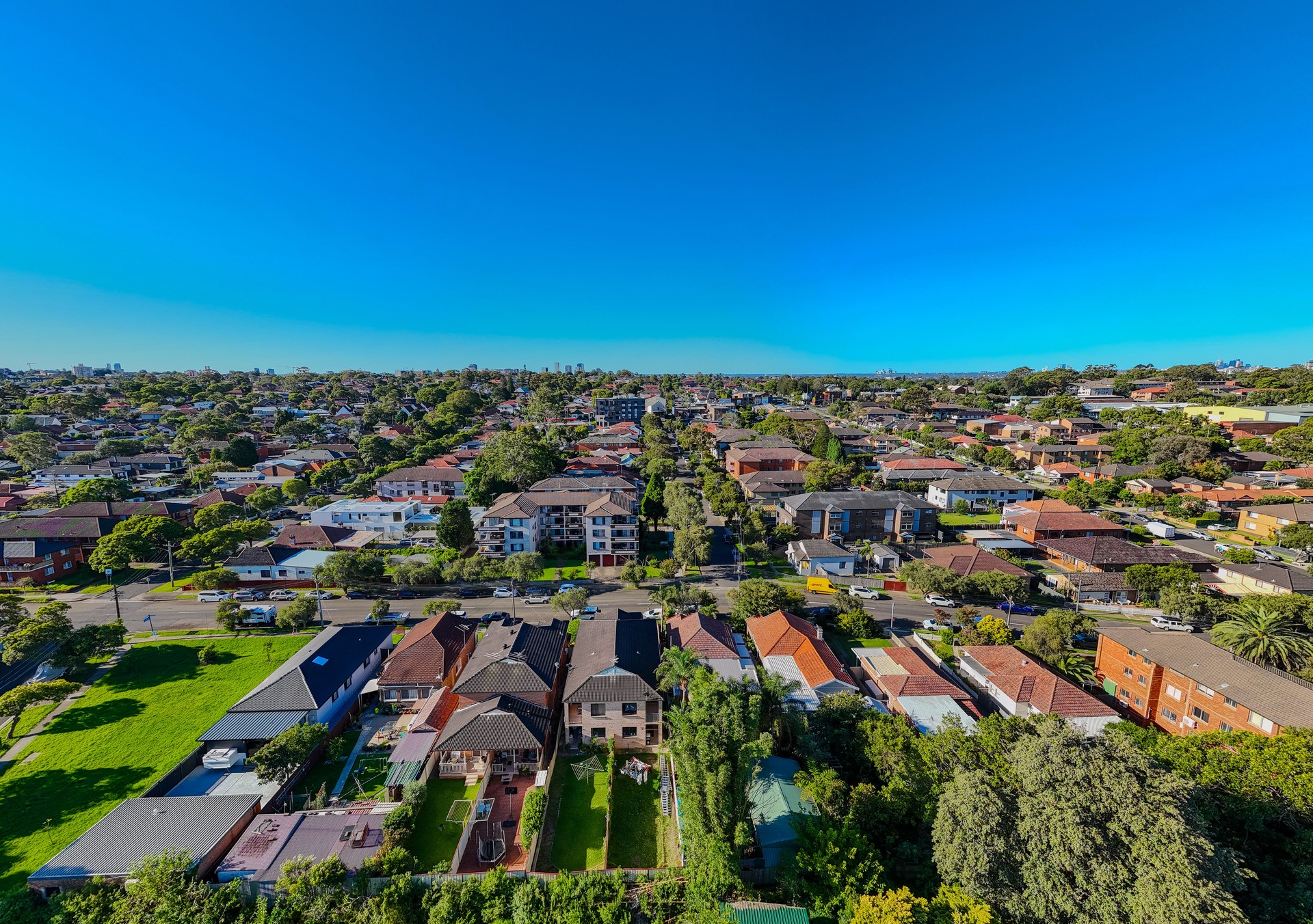 Drone view looking down on Commercial Suburb of Burwood in Sydney residential houses in suburbia suburban house roof tops and streets park NSW Australia